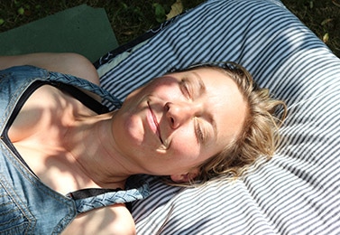 Woman relaxes, smiling with eyes closed